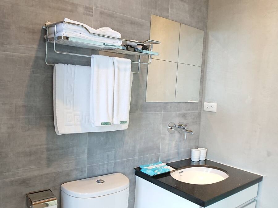 Ein modernes Badezimmer mit Toilette, Waschbecken und Spiegel.