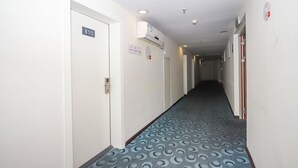 A hotel hallway with a patterned carpet, white walls, and doors numbered 810 and 811. - YuanMan Hotel (Huizhou)