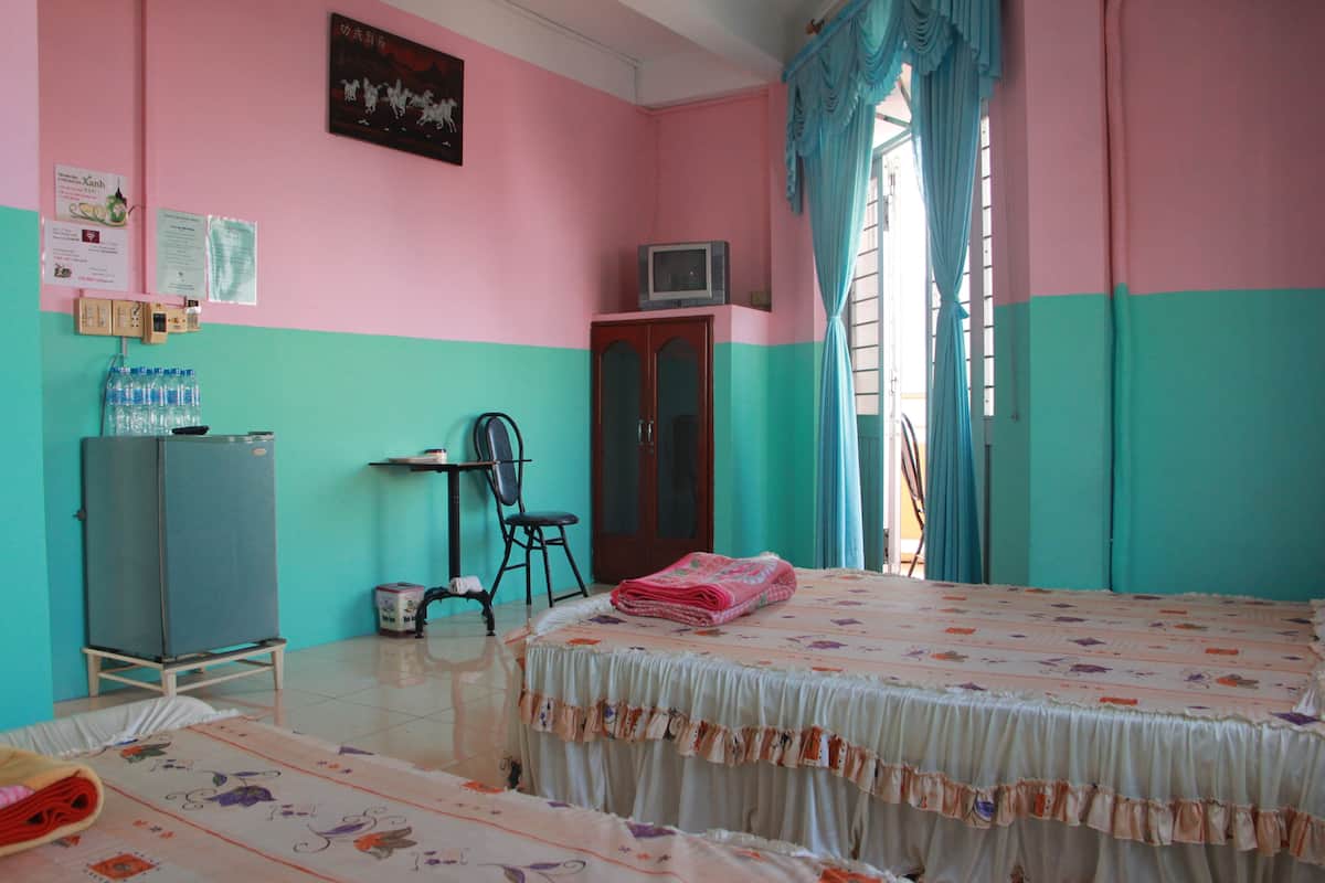 Een kamer met een bed, bureau, stoel, kledingkast en televisie.