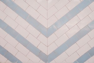 A pattern of light and dark tiles arranged in a chevron design.