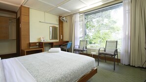 A hotel room with a bed, a desk, a chair, a mirror, and a window with curtains. - Bellevue The Penang Hill Hotel, Bukit Bendera (George Town)