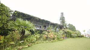 A modern building with a flat roof, surrounded by lush greenery and a well-maintained lawn. - Bellevue The Penang Hill Hotel, Bukit Bendera (George Town)