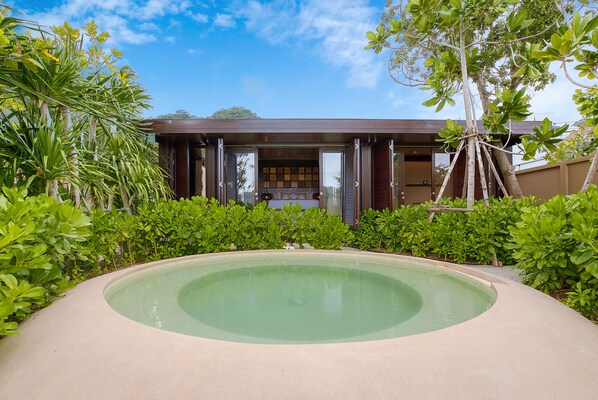 Ein modernes Haus mit Swimmingpool, umgeben von üppiger Vegetation.
