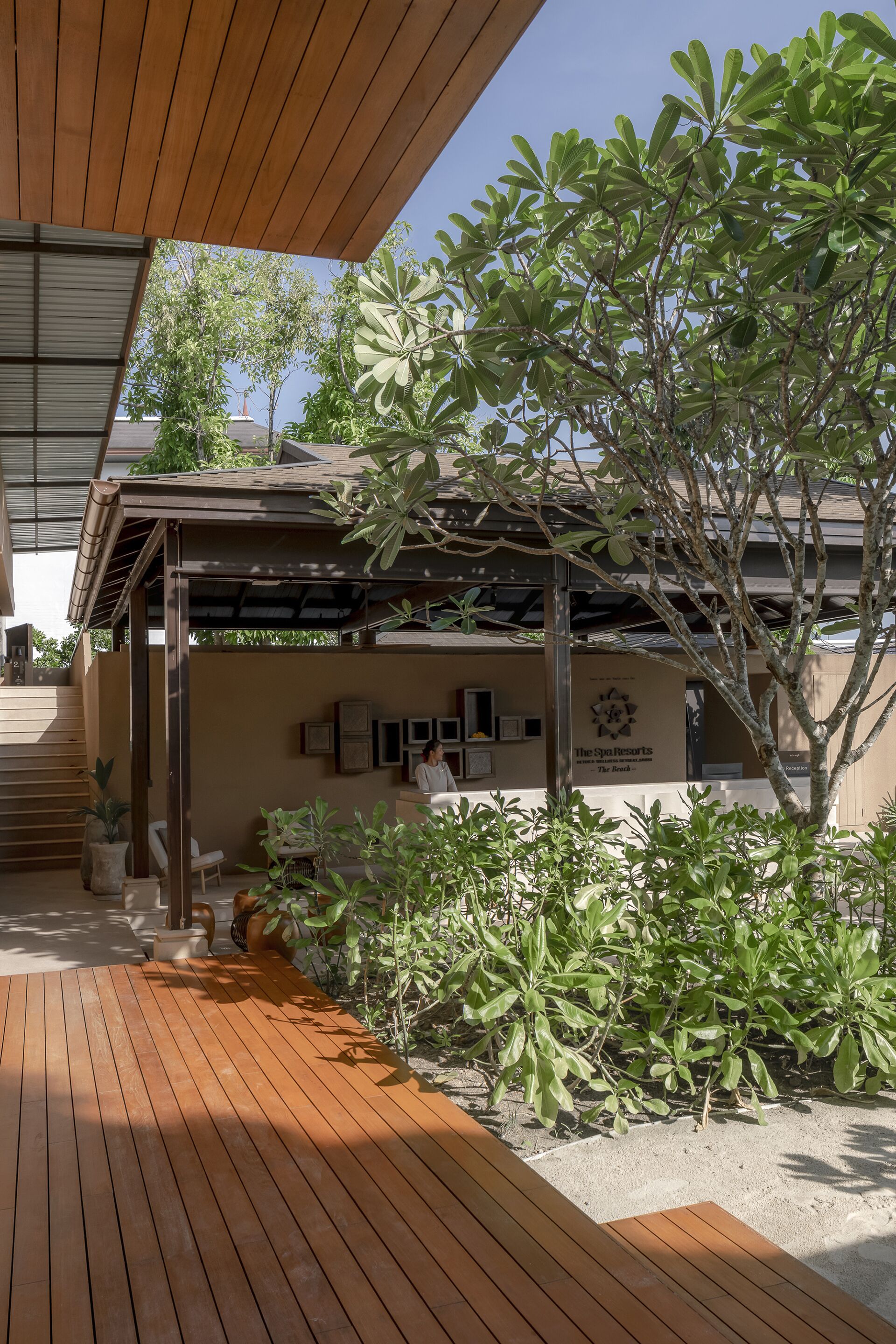 A wooden deck leading to a covered outdoor area with a sign for The Spa Resorts.