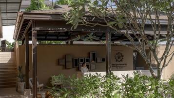 A wooden deck leading to a covered outdoor area with a sign for The Spa Resorts.