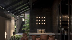 Un'area esterna moderna con posti a sedere, panchine, grandi fioriere e un fiorino a parete.