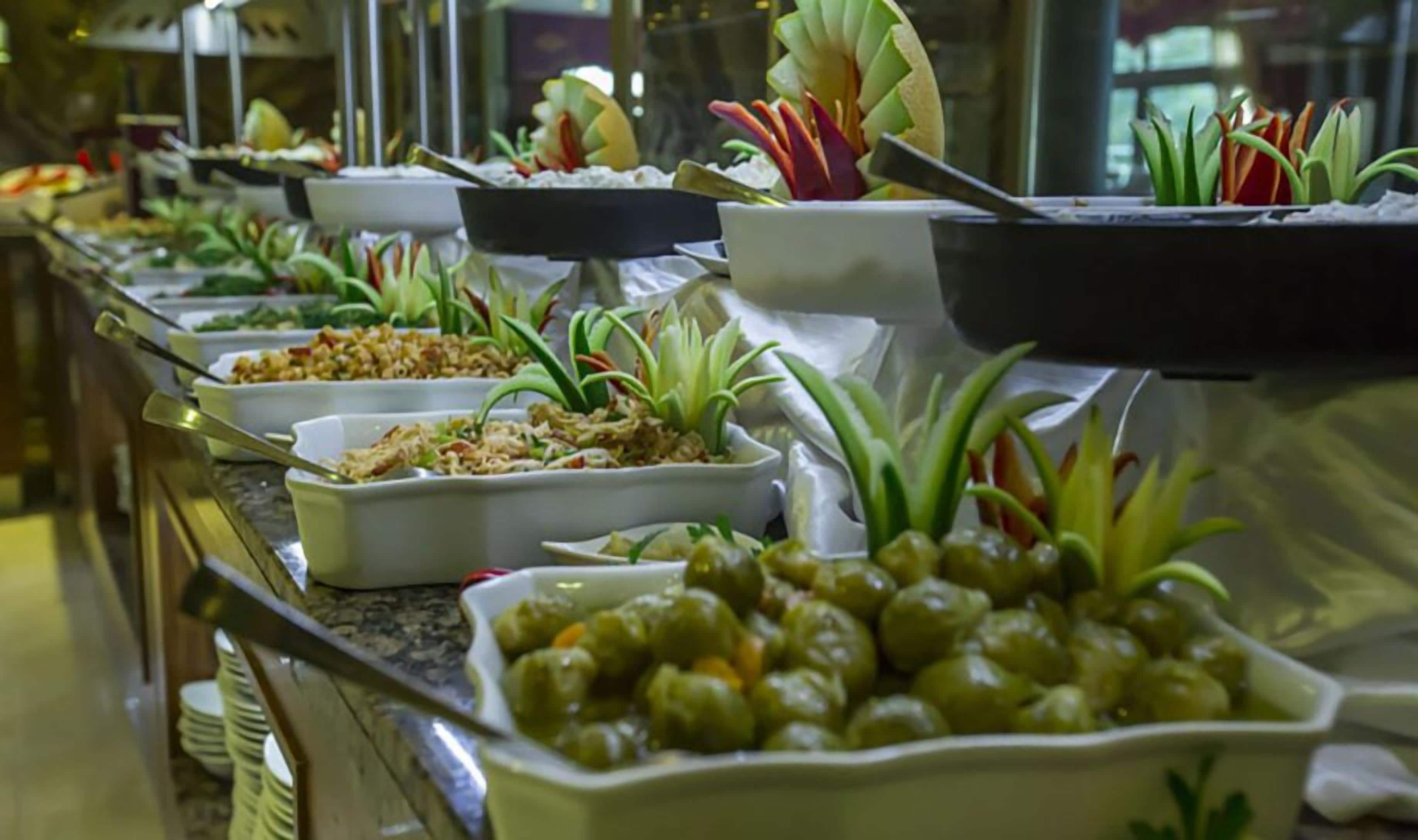 A buffet with various dishes and garnishes.