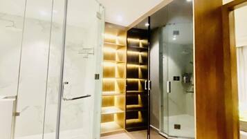 Enjoy a refreshing shower in the sleek bathroom, featuring a glass shower enclosure and walk-in closet with ample storage.