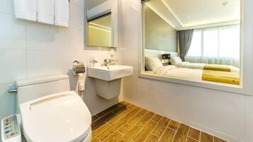 Une salle de bain moderne équipée de toilettes, d’un lavabo et d’un miroir.