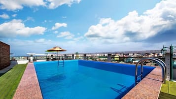 Relax by the rooftop pool, surrounded by a city view.