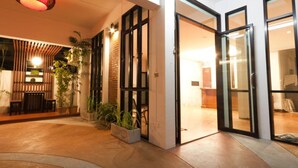 A modern building with large glass doors, a brick wall, and a ceiling light fixture. - Shan Boutique Hotel (Chiang Mai)