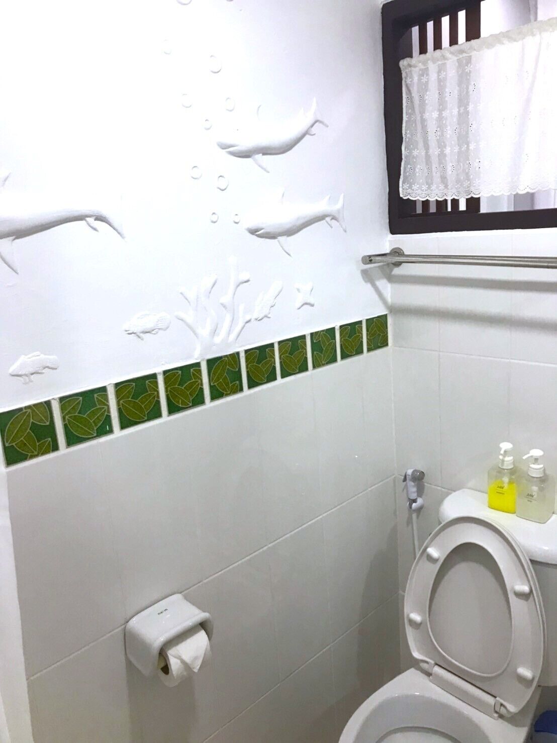 A bathroom with a toilet, a paper towel dispenser, and a hand dryer.