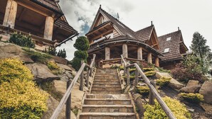 A wooden staircase leading to a traditional chalet with a steep roof and wooden beams. - Osada Kościelisko (Koscielisko)