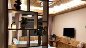 A bedroom with a wooden bunk bed, a TV mounted on the wall, and a wooden headboard.