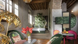 Een modern interieur met een groene bank, een klein rond tafeltje en een decoratieve lamp.