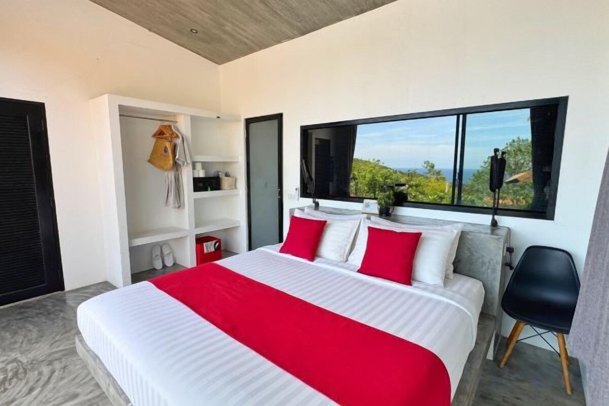 Une chambre moderne avec un grand lit, une armoire et un téléviseur.