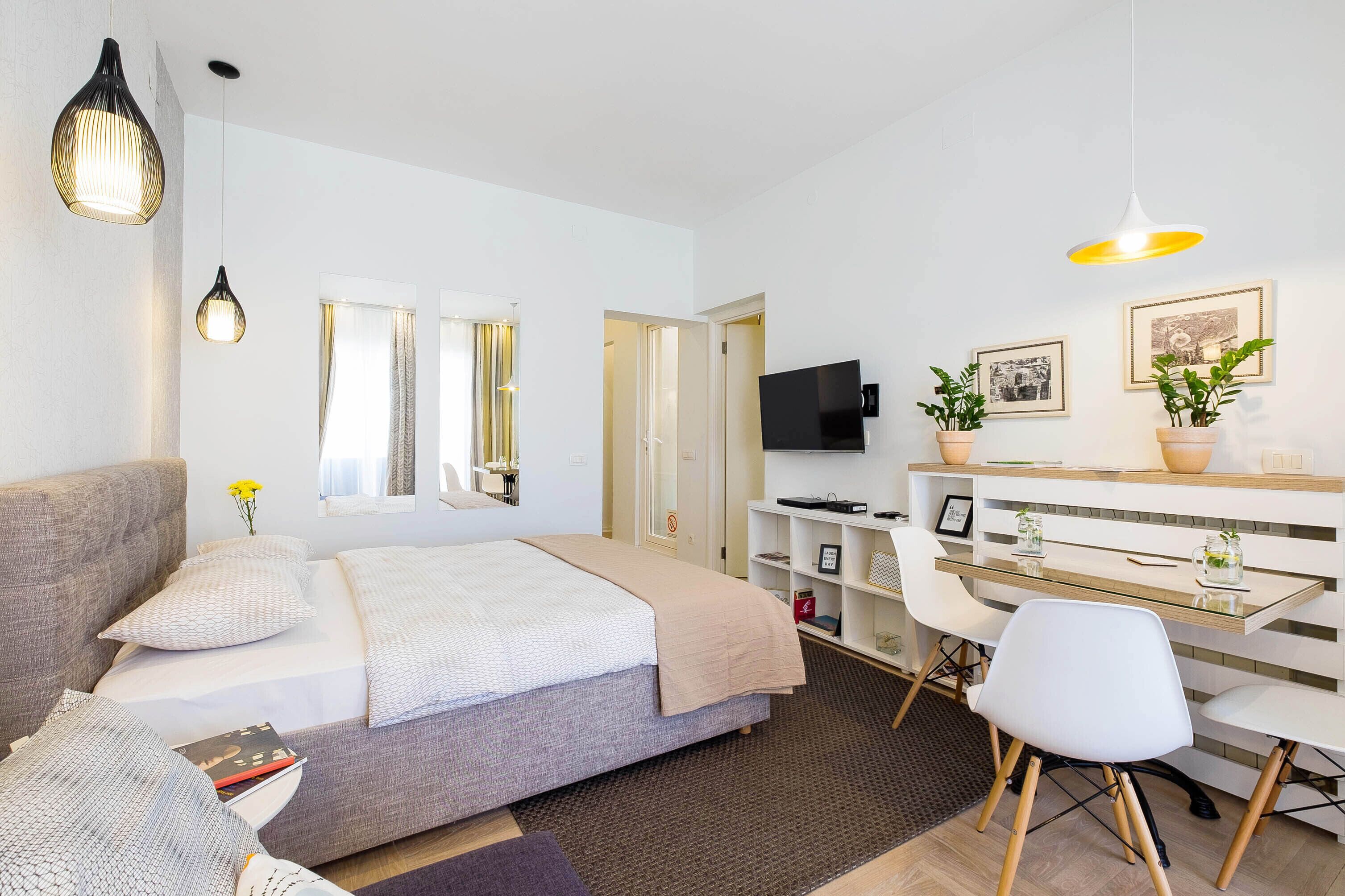 Une chambre moderne comprenant un lit, une table de chevet et un espace bureau avec une chaise.