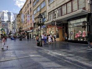 A busy urban street with shops and pedestrians. - Basco Knez Mihailova Apartments (Belgrade)