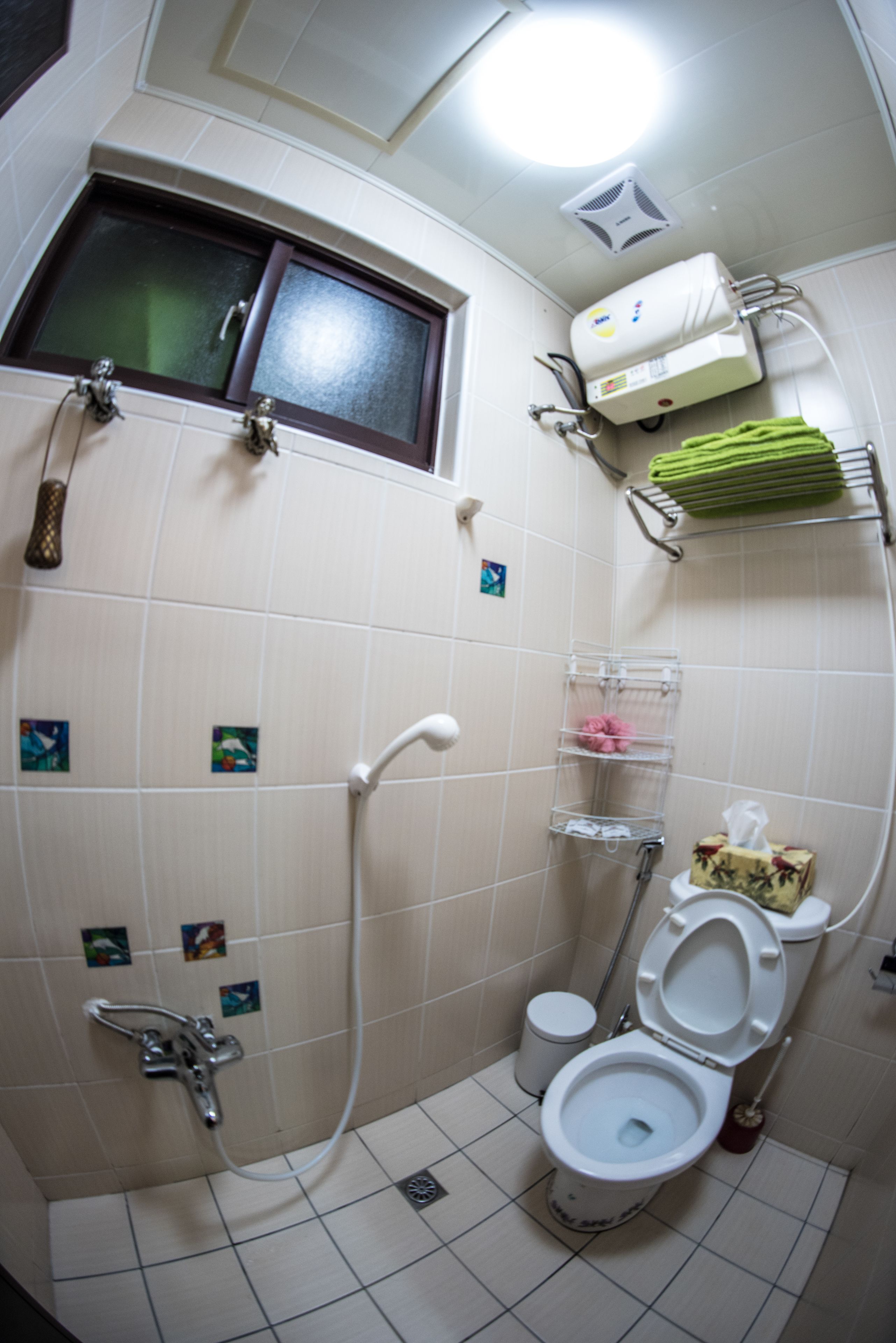 Un baño pequeño con ducha, inodoro y ventana.
