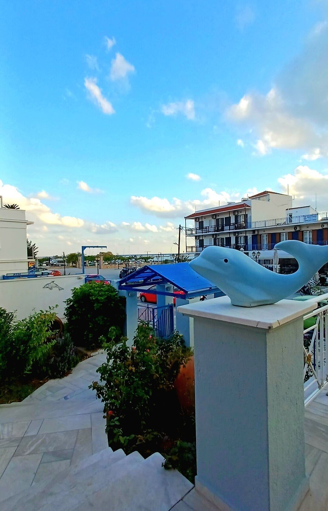 Um edifício com telhado azul e uma estátua branca na varanda.