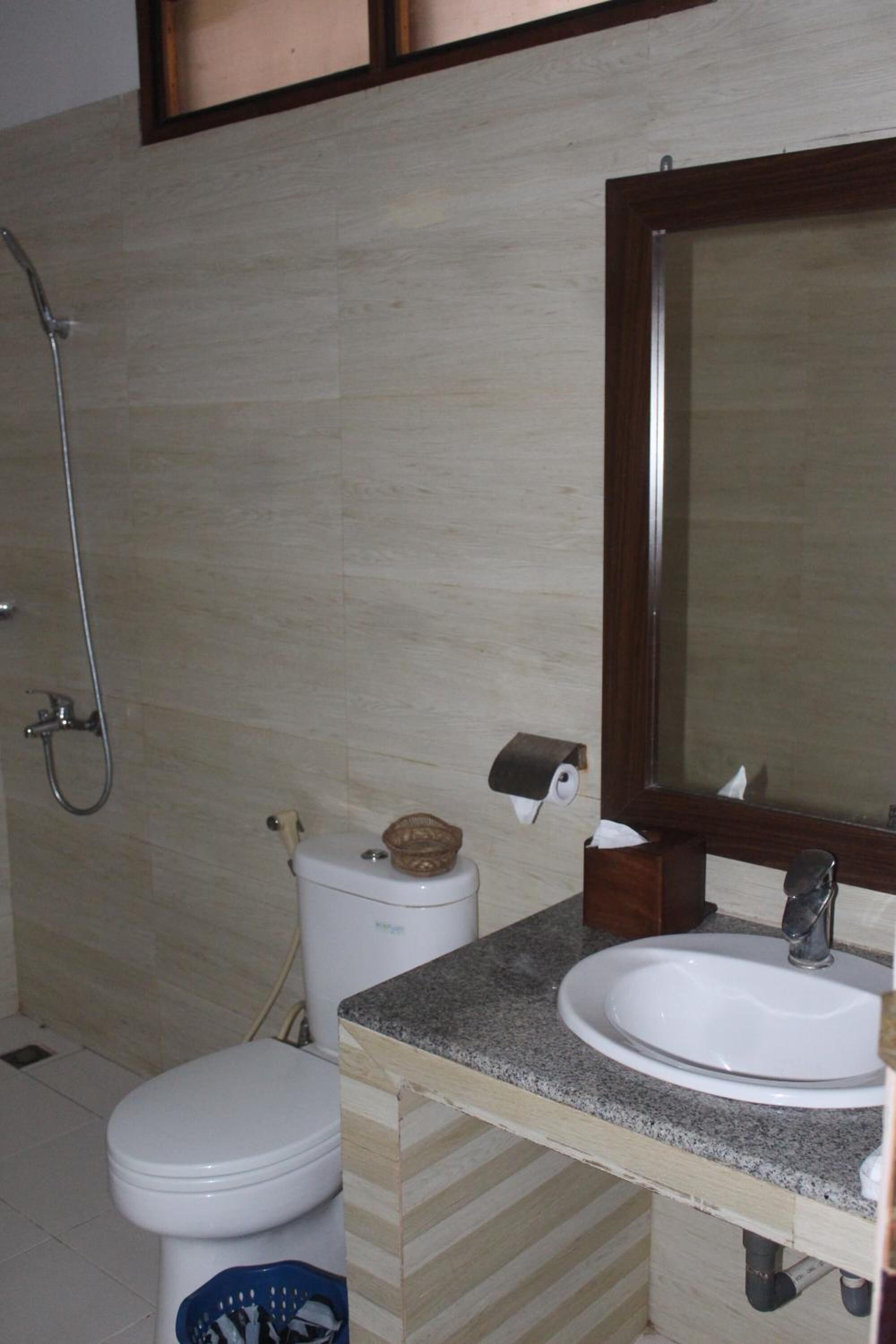 Un baño con inodoro, lavabo y ducha.