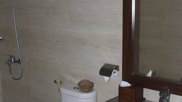Un baño con inodoro, lavabo y ducha.