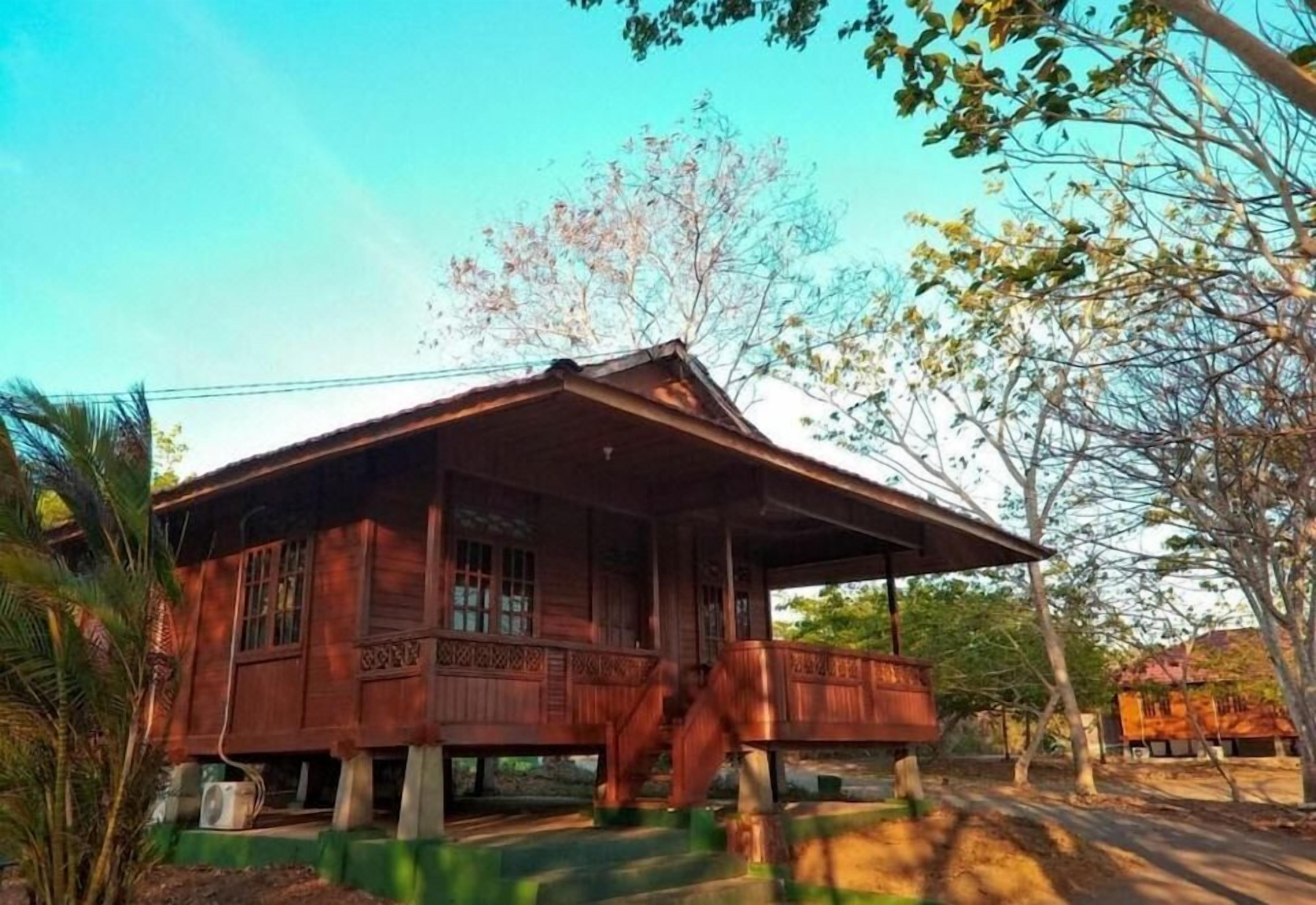 A wooden house with a porch and a staircase leading up to it.