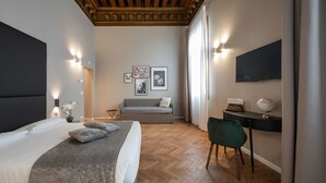 Une chambre avec un grand lit, un bureau, une chaise et un canapé.