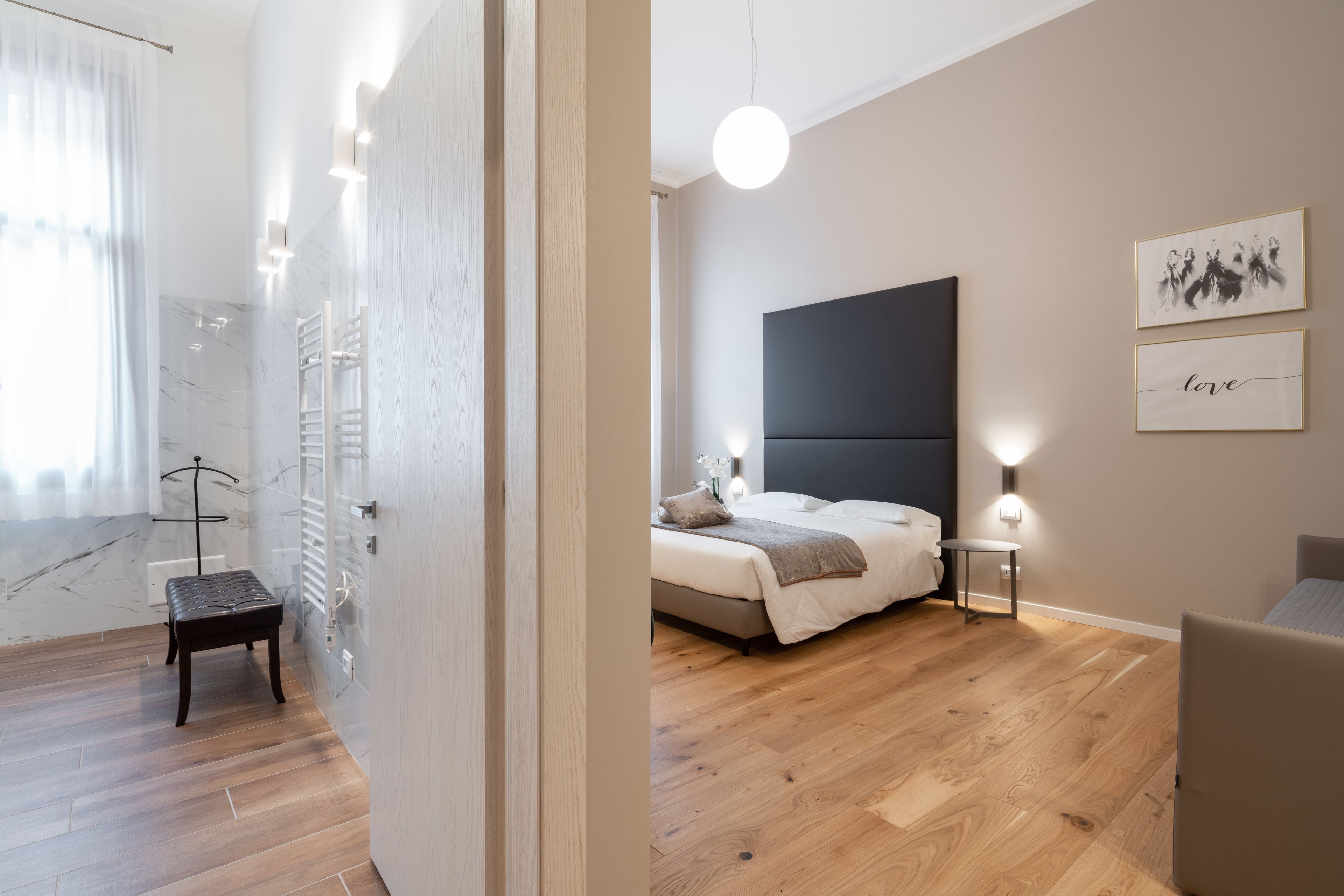 Un dormitorio moderno con una cama, mesitas de noche y una obra de arte en la pared.