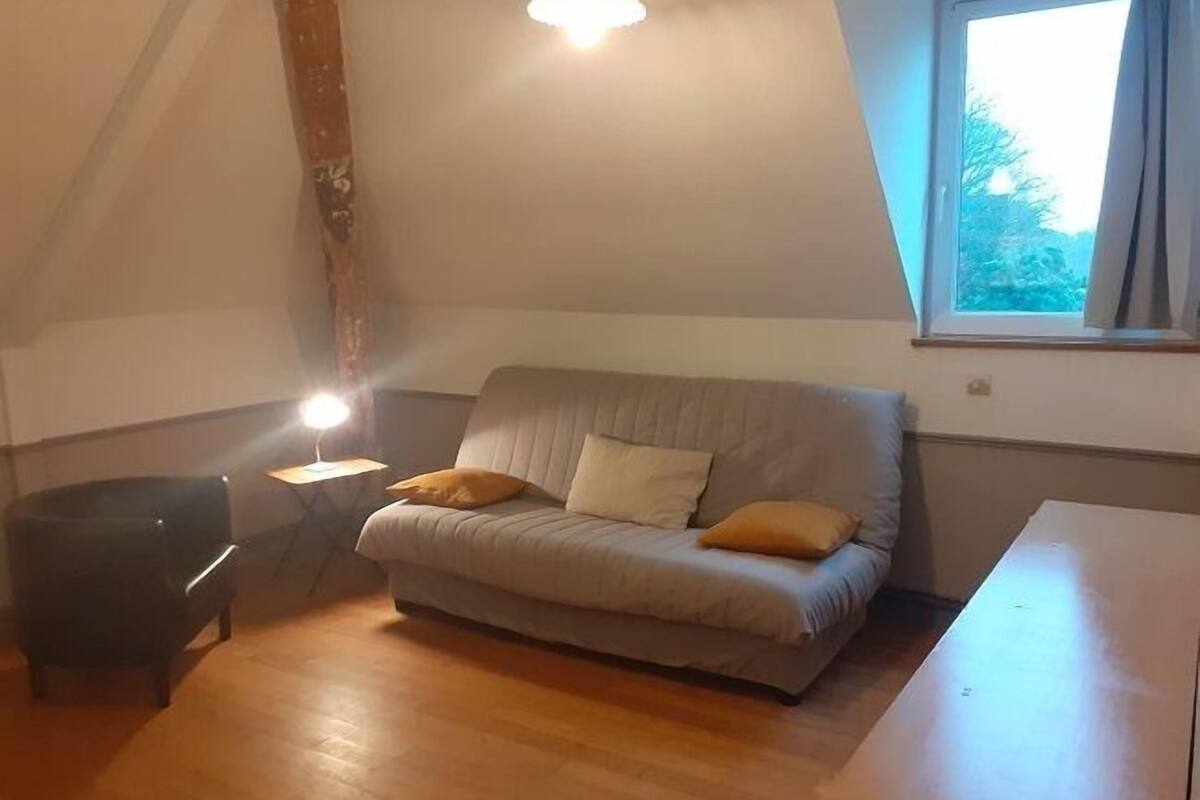 Una habitación acogedora con un sofá, una mesita y una ventana.