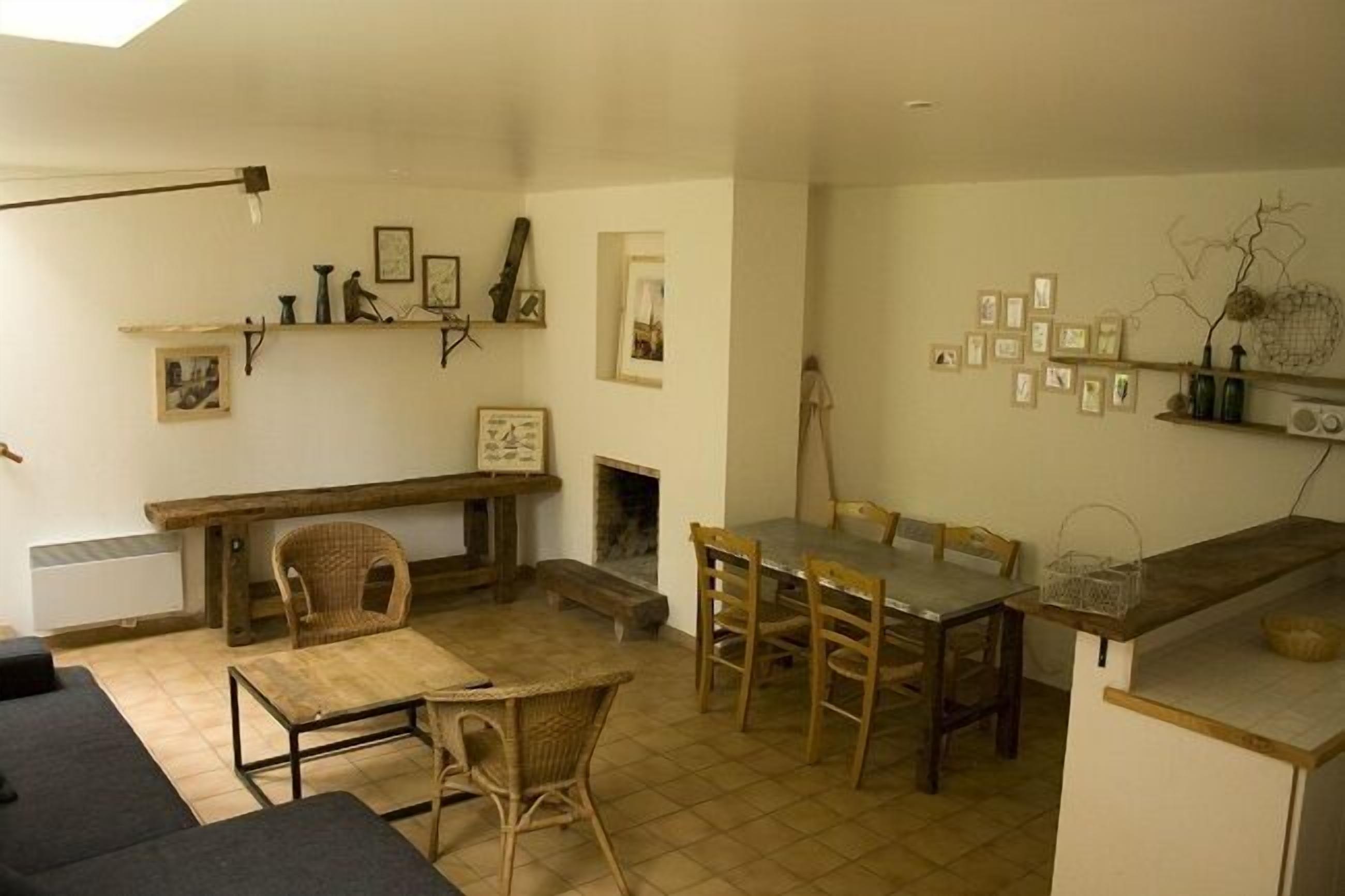 Uma sala de estar aconchegante com lareira, uma mesa de jantar e um sofá.