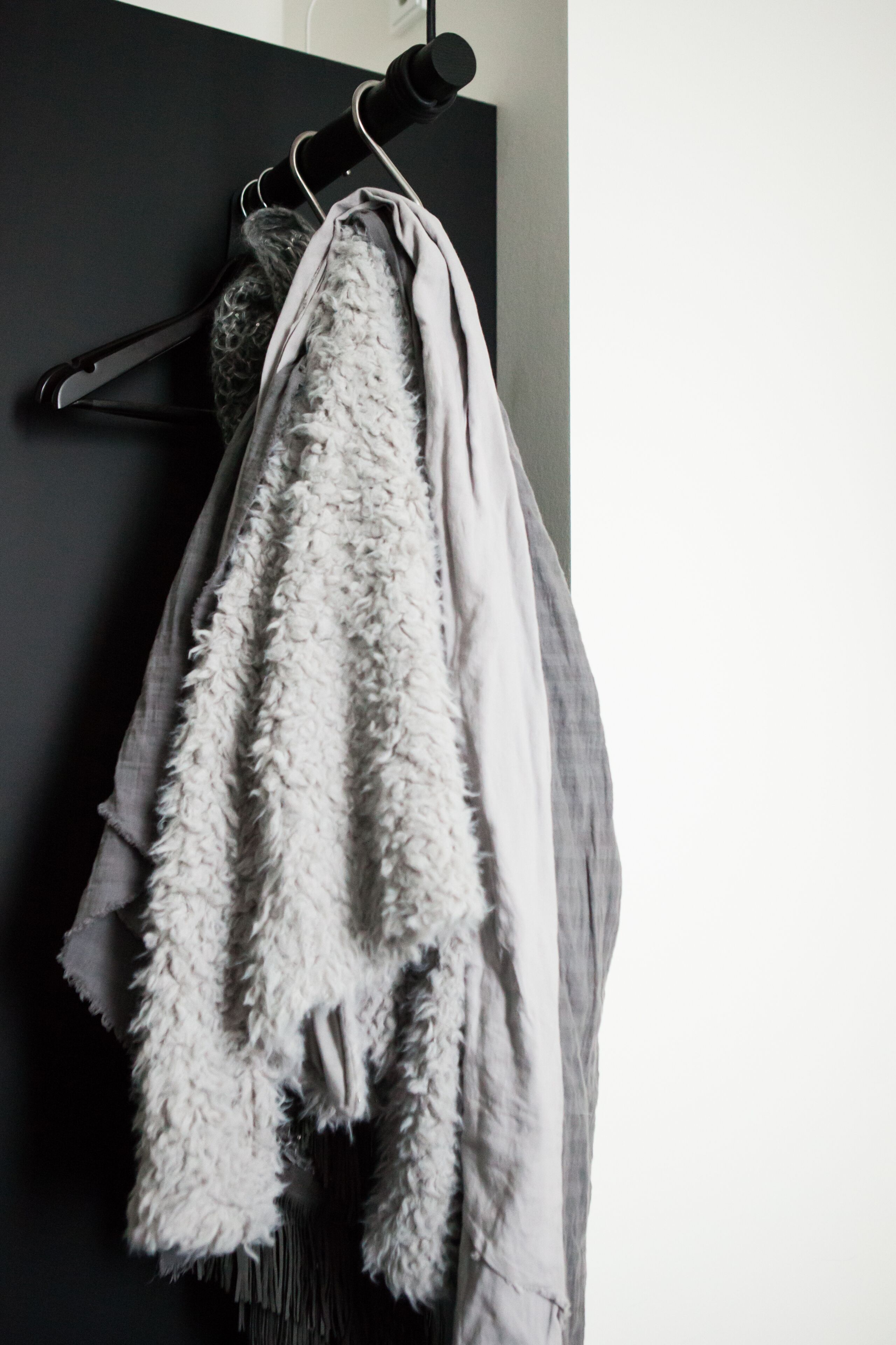 Une porte noire avec une serviette blanche suspendue à un crochet.