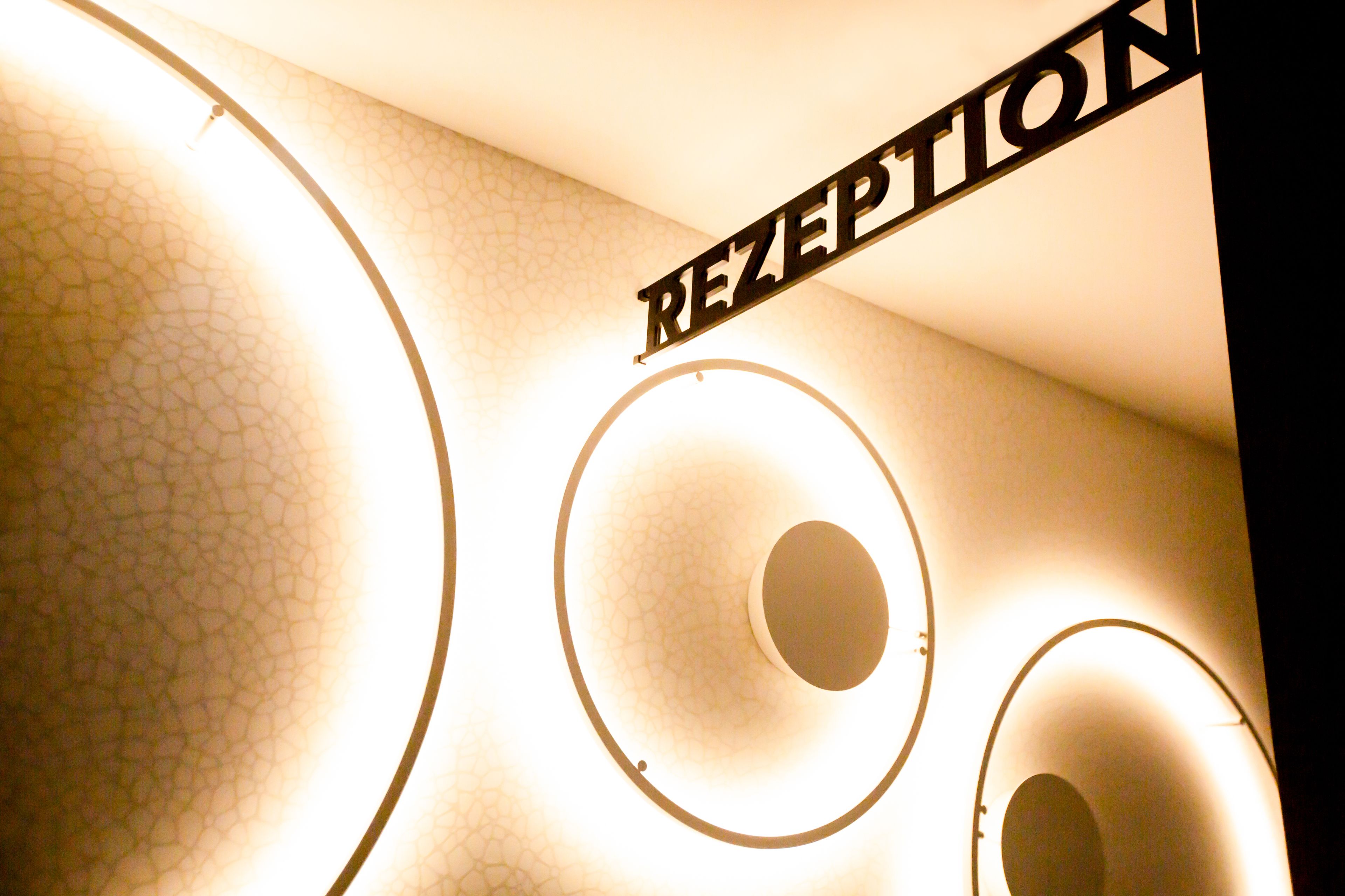 A reception area with a sign that reads "RECEPTION" and circular light fixtures.