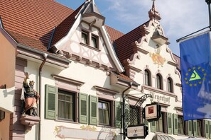 A historic building with a traditional European architectural style, featuring a prominent clock tower and a flag with the European Union emblem. - Hotel Meyerhof Lörrach (Loerrach)