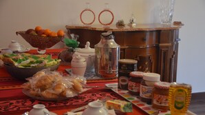 A breakfast table with various food items, including croissants, a fruit bowl, and condiments. - Smiling Naples (Naples)