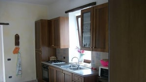 Eine Küche mit Holzausstattung, einem Gasherd, einer Spüle und einem Fenster mit Blick ins Freie.