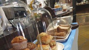 A buffet with various baked goods like muffins and scones displayed on a table with a blue tablecloth. - Lalapanzi Hotel and Conference Centre (Louis Trichardt)