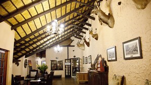 A rustic interior with wooden beams, a chandelier, and mounted animal heads on the wall. - Lalapanzi Hotel and Conference Centre (Louis Trichardt)