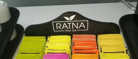 A tray with neatly organized tea bags labeled with different flavors like Earl Grey, English, and Forest.