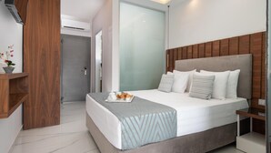 A modern hotel room with a large bed, a wooden headboard, and a bedside table. - 4-You (Polygyros)