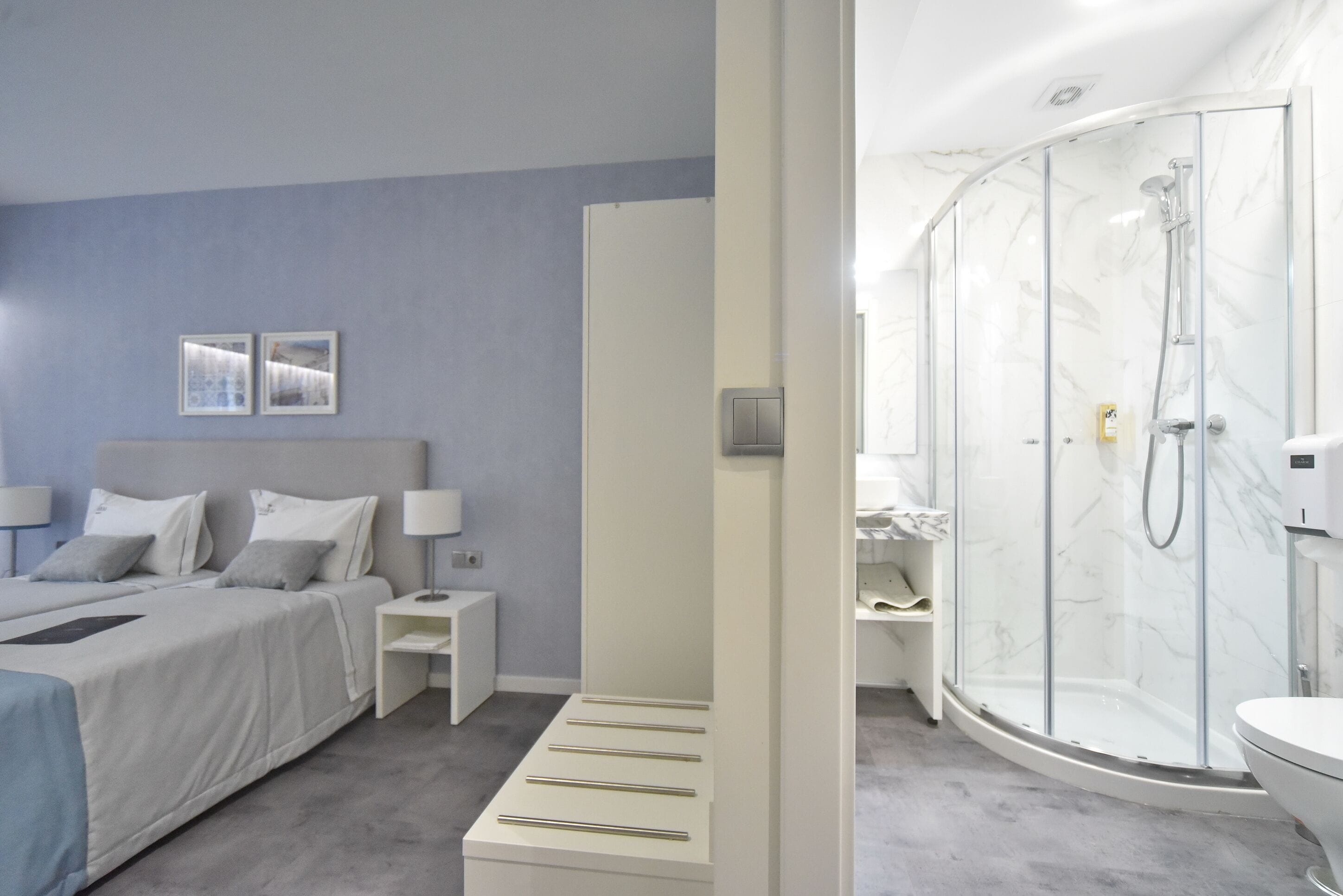 Un dormitorio moderno con una cama, mesitas de noche y una mesilla.