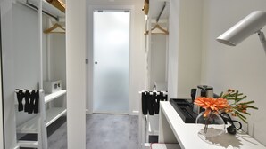 A modern bathroom with a white sink, a mirror, and a towel rack.