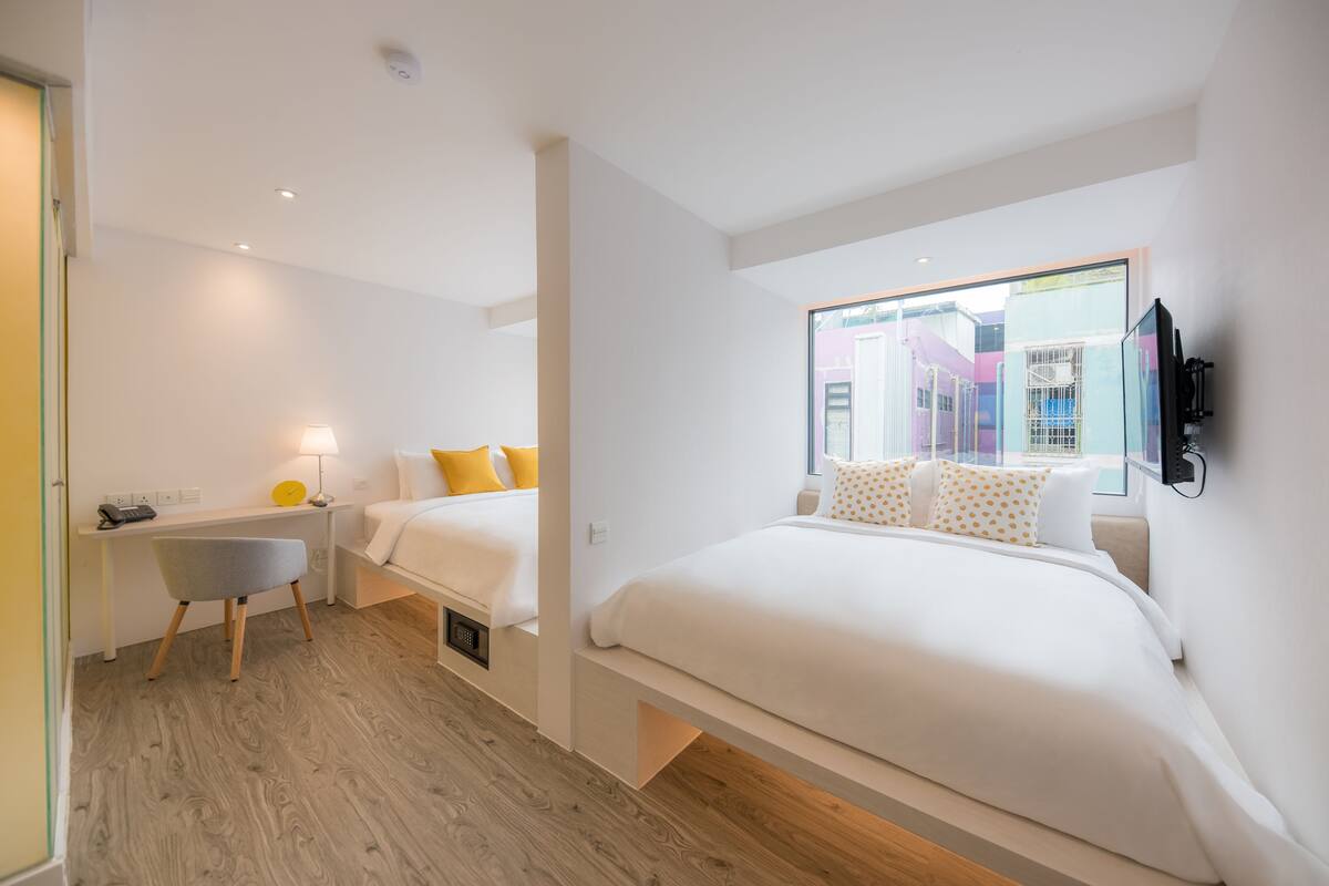 Een moderne hotelkamer met een groot bed, een bureau en een stoel.
