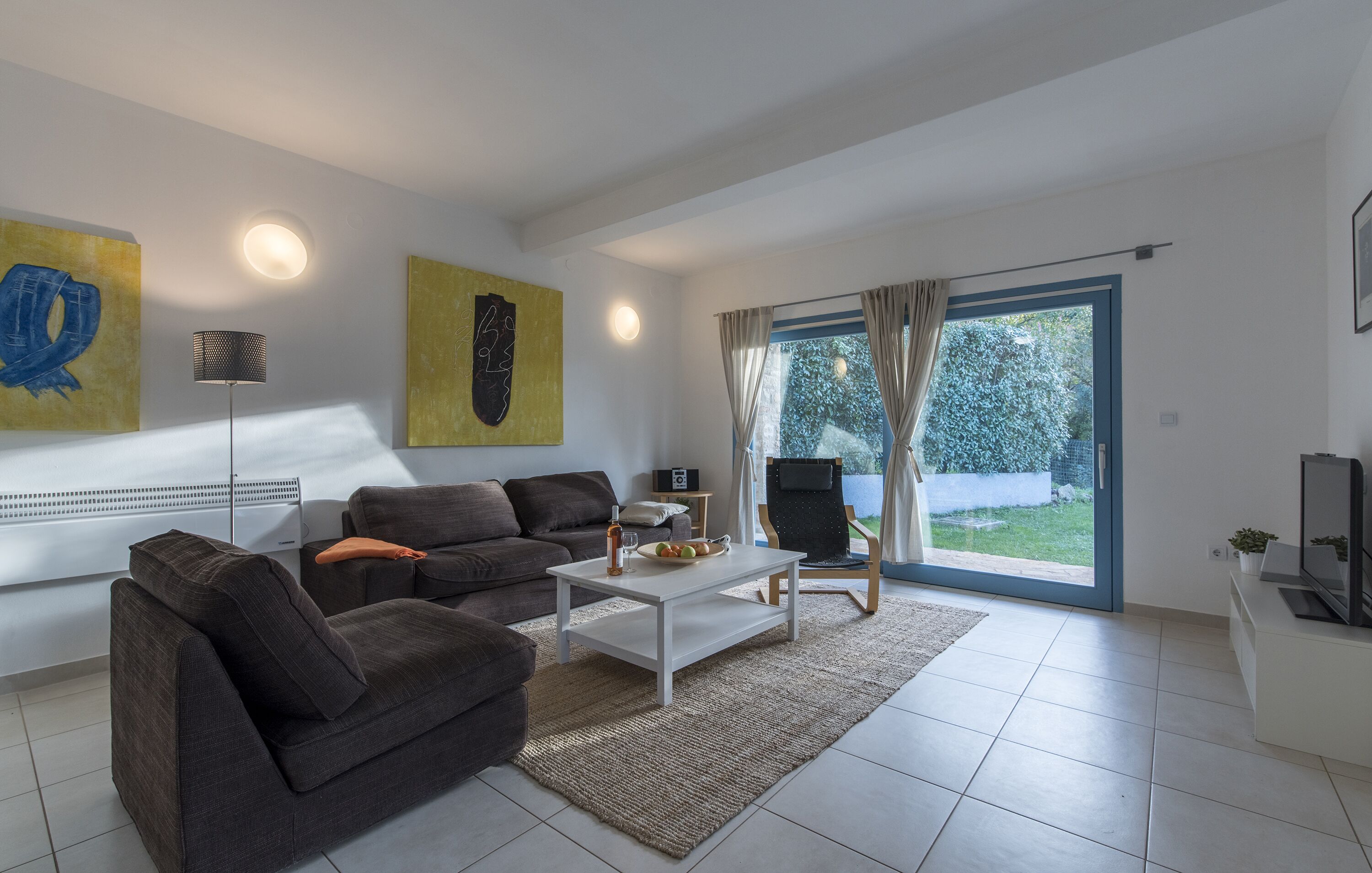 A modern living room with a sofa set, a coffee table, and a television.