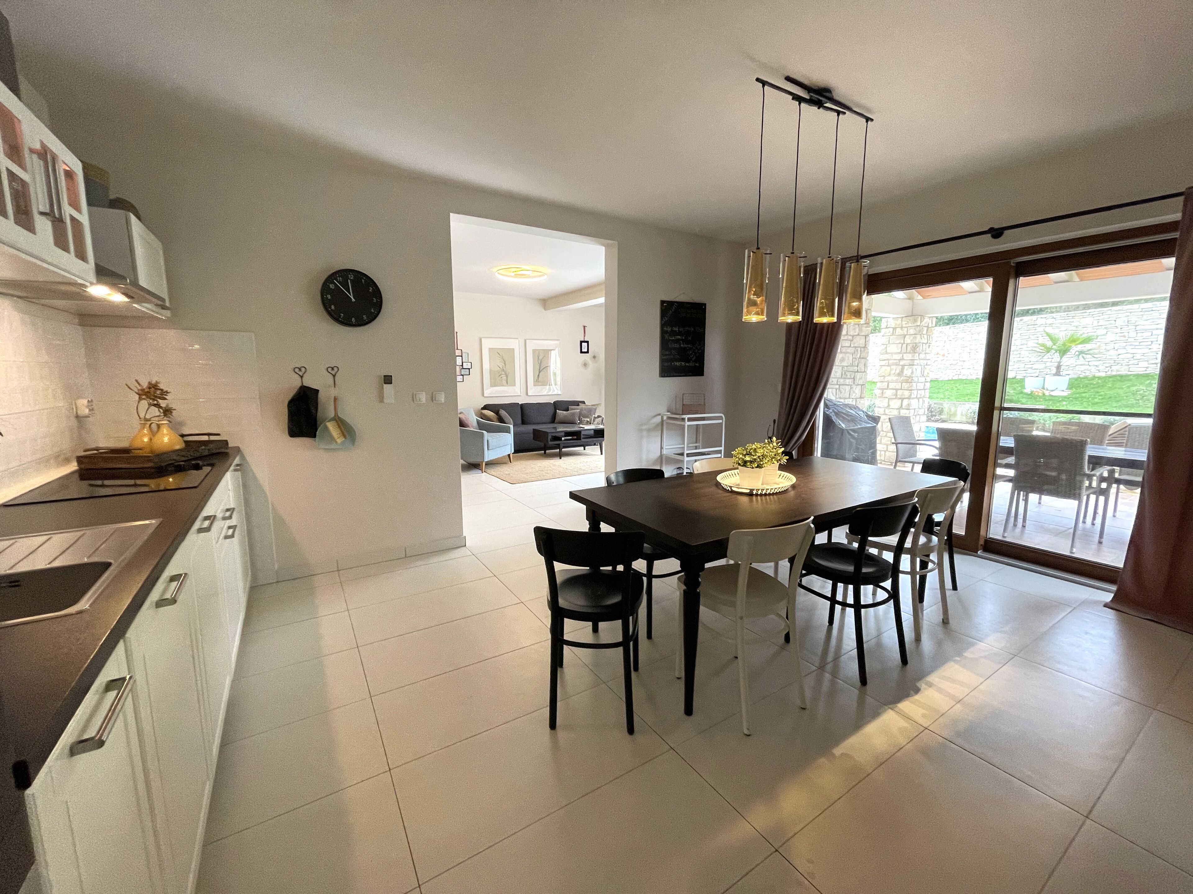 A modern kitchen with a dining area, a large window, and a view of the outdoors.
