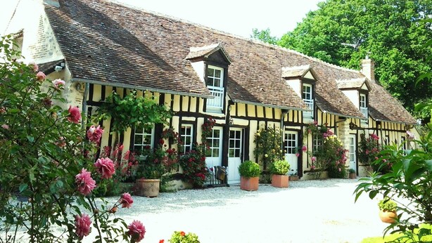 A traditional half-timbered house with a gravel driveway and potted plants. - Les Sapins (Vitry-aux-Loges)