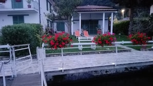 A wooden dock leading to a water body, with a white railing and rope. - Villa Anastasye (Predore)