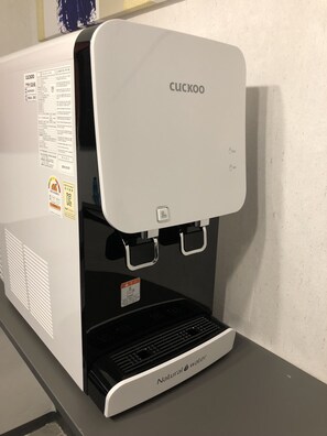 A Cuckoo branded coffee machine with a water filter and a hot water dispenser. - Blue Mansion Guesthouse (Seoul)