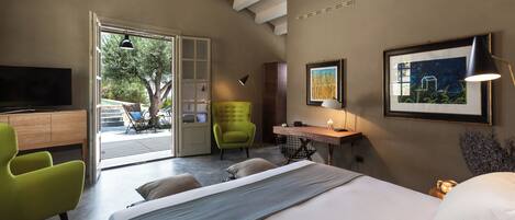 Un dormitorio moderno con cama, escritorio, silla verde y televisor.