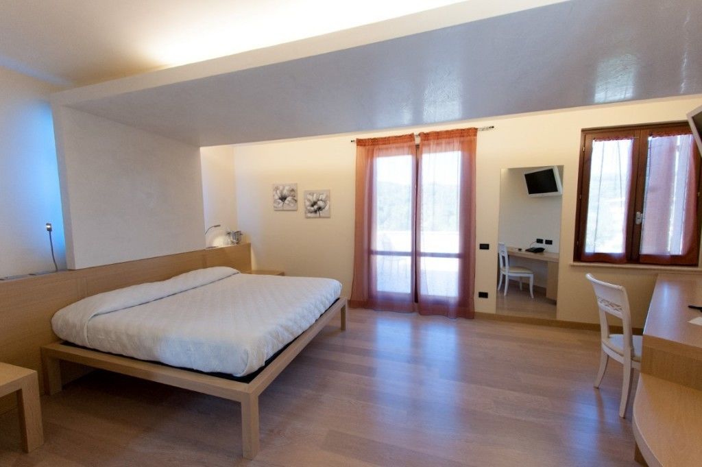 Un dormitorio con cama, escritorio, silla y televisor.
